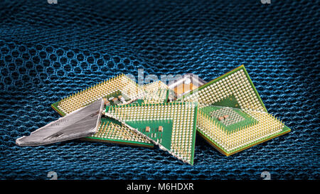 Broken computer processors on hexagonal textured mesh. Background from shards of microchips with critical bug. Cyber security, electronics industry. Stock Photo
