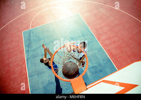 High angle view of basketball player dunking basketball in hoop Stock Photo