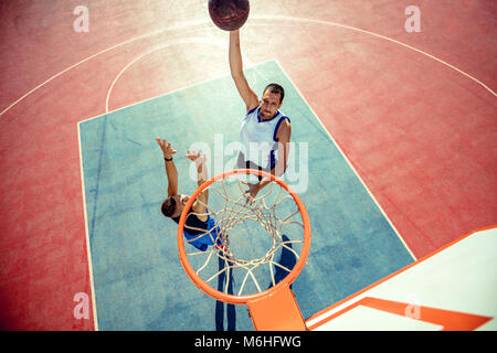 High angle view of basketball player dunking basketball in hoop Stock Photo