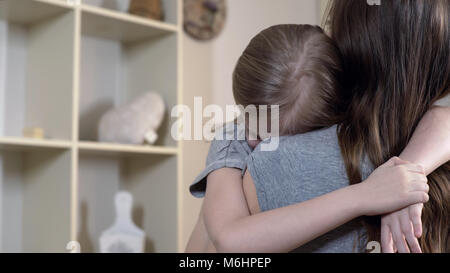 Sad daughter tightly hugging her mother telling about her problems, mother love Stock Photo