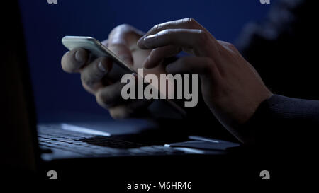 Scammer holds smartphone, cracks two-factor authentication, steals money online Stock Photo