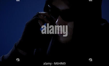 Dangerous criminal threatening victim by phone, demanding money via blackmail Stock Photo