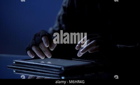 Man illegally viewing confidential files on tablet, secret information leakage Stock Photo