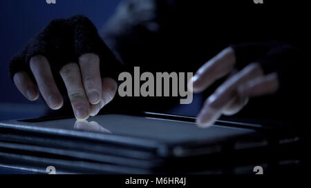 Hacker using tablet pc to hack bank account and steal money, financial crime Stock Photo