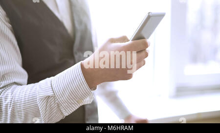 Company employee dialing number on cellphone, calling business partner, office Stock Photo