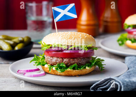 Burger on a plate with pickles. Wooden background. Stock Photo