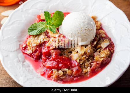 Crumble with berries and fruits with vanilla ice cream. Stock Photo