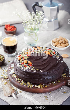 Vegan chocolate beet cake with avocado frosting, decorated with nuts and seeds. Stock Photo