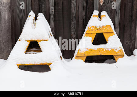 Yellow A-frame barrier supports covered in fresh snow Stock Photo