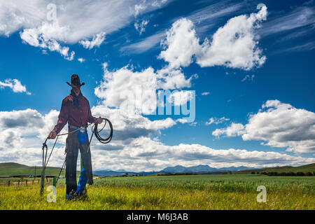 Cowboy metal silhouette near Bar U Ranch National Historic Site in foothills of the Rocky Mountains, in far distance, near Longview, Alberta, Canada Stock Photo