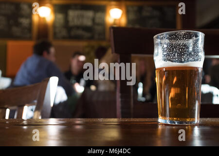 Half drunk pint of beer in pub, Camden, London, England Stock Photo