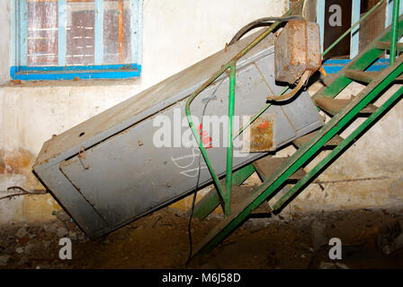 Old dismantled and rusty electrical panel assembly on an abandoned and destroyed factory against a backdrop of chaos. Destruction and vandalism. Ukrai Stock Photo