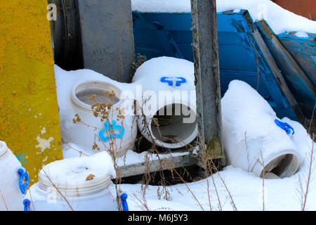 Old and rusty discarded ventilation in an abandoned and destroyed factory against white snow. Destruction and vandalism. Ukraine. Stock Photo