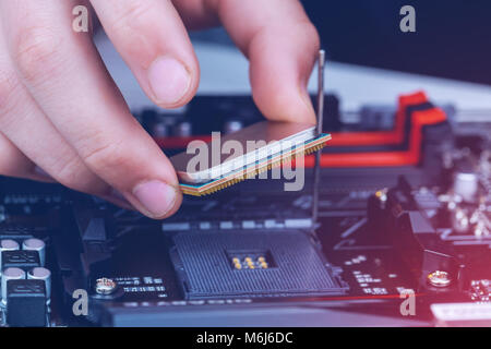 Installation of modern processor in CPU socket on the motherboard Stock Photo