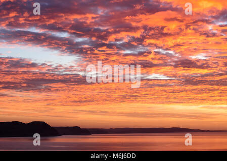 Rare vivid orange fire colours in the morning sky over the Jurassic Coast in November 2011 Stock Photo