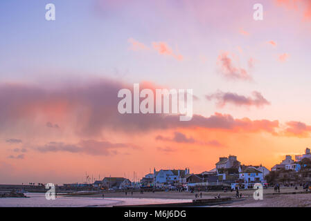 Beautiful orange and blue hues in the sky as the sun sets over Lyme Regis in January 2018. Stock Photo