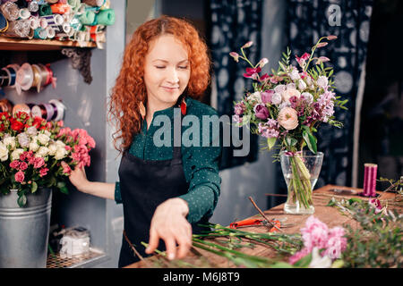 snapshot of good-looking floral assistant counting flowers for bouquet Stock Photo