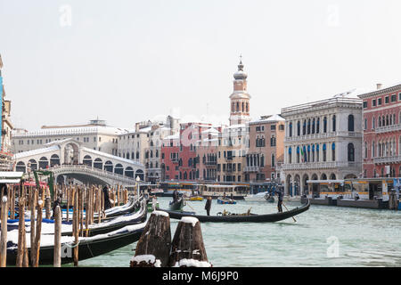 Snow covered Rialto Bridge and Grand Canal, Venice, Veneto, Italy with gondolas cleaning the gondolas during the Siberian weather front in January 201 Stock Photo