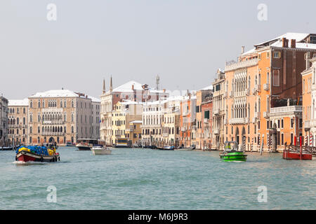 Busy boat traffic in front of snow covered Palazzos on the  Grand Canal, San Polo, Venice,  Veneto, Italy during the severe winter weather with the Si Stock Photo