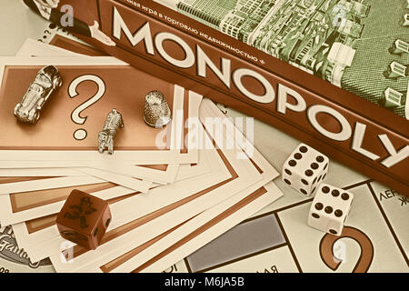 Tambov, Russian Federation - January 26, 2018 Monopoly Board Game box, Chance cards, tokens, dices on the gameboard. Studio shot. Stock Photo