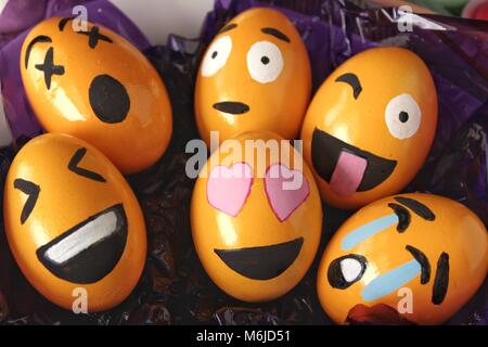 Emoticons Easter Eggs on purple cellophane paper Stock Photo