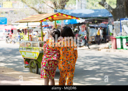 Cambodia children - two young cambodian girls aged 10 years seen from the back in colourful clothes, Kep, Cambodia, Asia Stock Photo