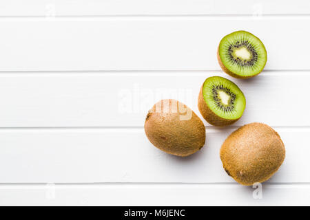 Halved kiwi fruit on white table. Stock Photo