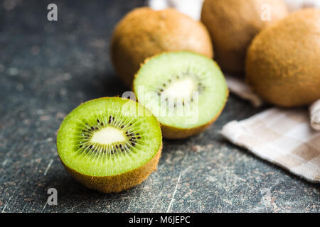 Halved kiwi fruit on old kitchen table. Stock Photo