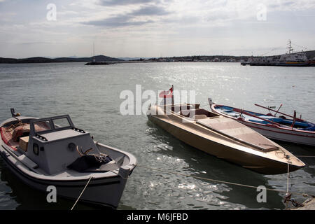 Modern and traditional boats at seaside of Cunda (Alibey) Island's old town. Calm Aegean sea and landscape are in the background. Stock Photo