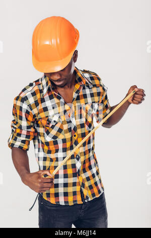 African-American builder uses measuring tape Stock Photo