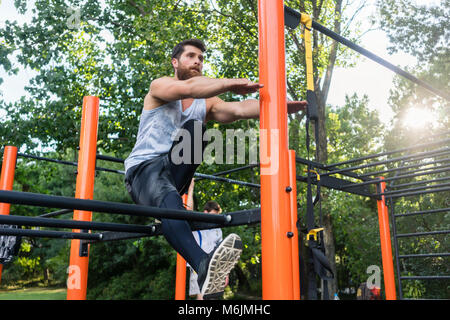 Determined handsome man doing extreme single-leg squats Stock Photo