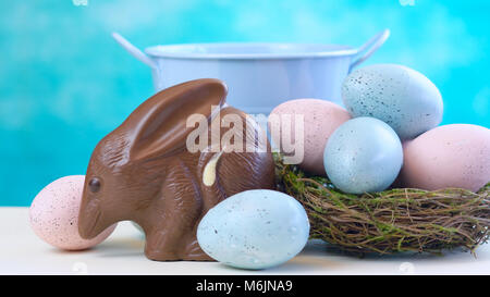Australian milk chocolate Bilby Easter egg with eggs in nest against a blue and white background Stock Photo