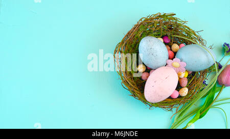 Happy Easter overhead with Easter eggs and decorations on a wood table background with copy space. Stock Photo