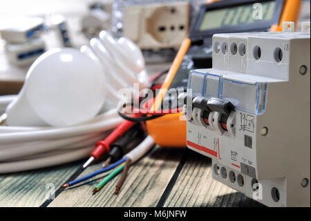 Close-up of switches for electrical panel and other components for residential electrical installation on rustic wooden table Stock Photo