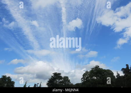 A bright blue sky with whispy streaks and puffs of clouds on a summer's day in Derbyshire, England, UK Stock Photo