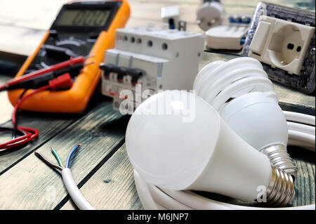 Close-up light bulbs and other components for residential electrical installation on rustic wooden table Stock Photo