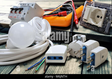Close up of plugs and sockets and other components for residential electrical installation on rustic wooden table Stock Photo
