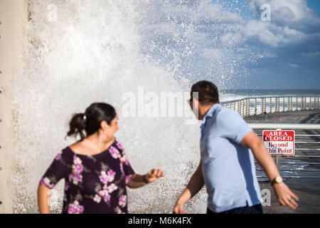 Boynton Beach, FL, USA. 4th Mar, 2018. A couple try to avoid a huge wave as it crashes against one of the piers at the Boynton Beach Inlet on Sunday, March 3rd, 2018. Jennifer Lett, Sun Sentinel Credit: Sun-Sentinel/ZUMA Wire/Alamy Live News Stock Photo