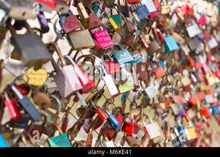 Colorful locked love locks on a bridge in Salzburg Austria. Lovers throuw away the key to express their love. Shallow DOF. Stock Photo