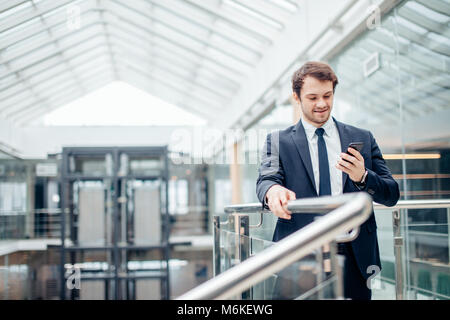 businessman with smartphone over office building Stock Photo