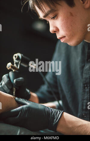 Professional tattooist makes the tattoo Stock Photo