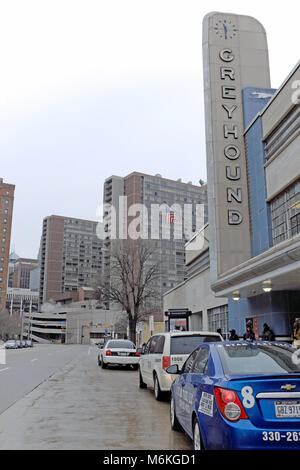 An overcast winter sky in downtown Cleveland, Ohio provides a backdrop for the Cleveland Ohio Greyhound Bus terminal with people and cars out front. Stock Photo