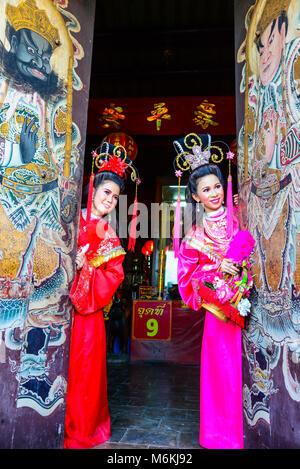 Chachoengsao, Thailand - July 14, 2013 : Beautiful women with traditional chinese dress at Chinese shrine door with painting of ancient soldier in Tha Stock Photo