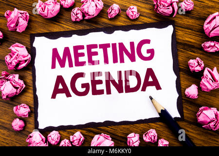 Hand writing text caption inspiration showing Meeting Agenda. Business concept for Business Schedule Plan Written on sticky note paper, wooden backgro Stock Photo