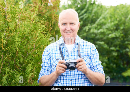 Happy Senior Man Taking Photos in Park Stock Photo