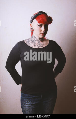 edgy portrait of a young woman with many facial piercings and tattoos Stock Photo