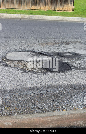 Damaged asphalt road with potholes in Melbourne Australia Stock Photo