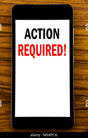 Handwriting Announcement text showing Action Required. Business concept for Immediate Urgent Written on mobile cellphone with wooden background with s Stock Photo