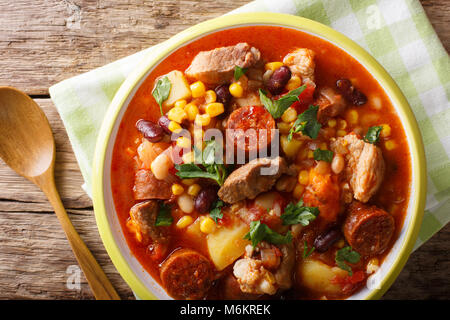National cuisine of Cape Verde: Cachupa with meat, chorizo and vegetables close-up on a plate on a table. horizontal top view from above Stock Photo