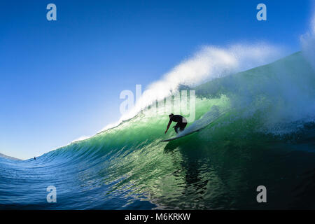 Surfing surfer tube rides ocean wave morning silhouetted water action photo unidentified Stock Photo
